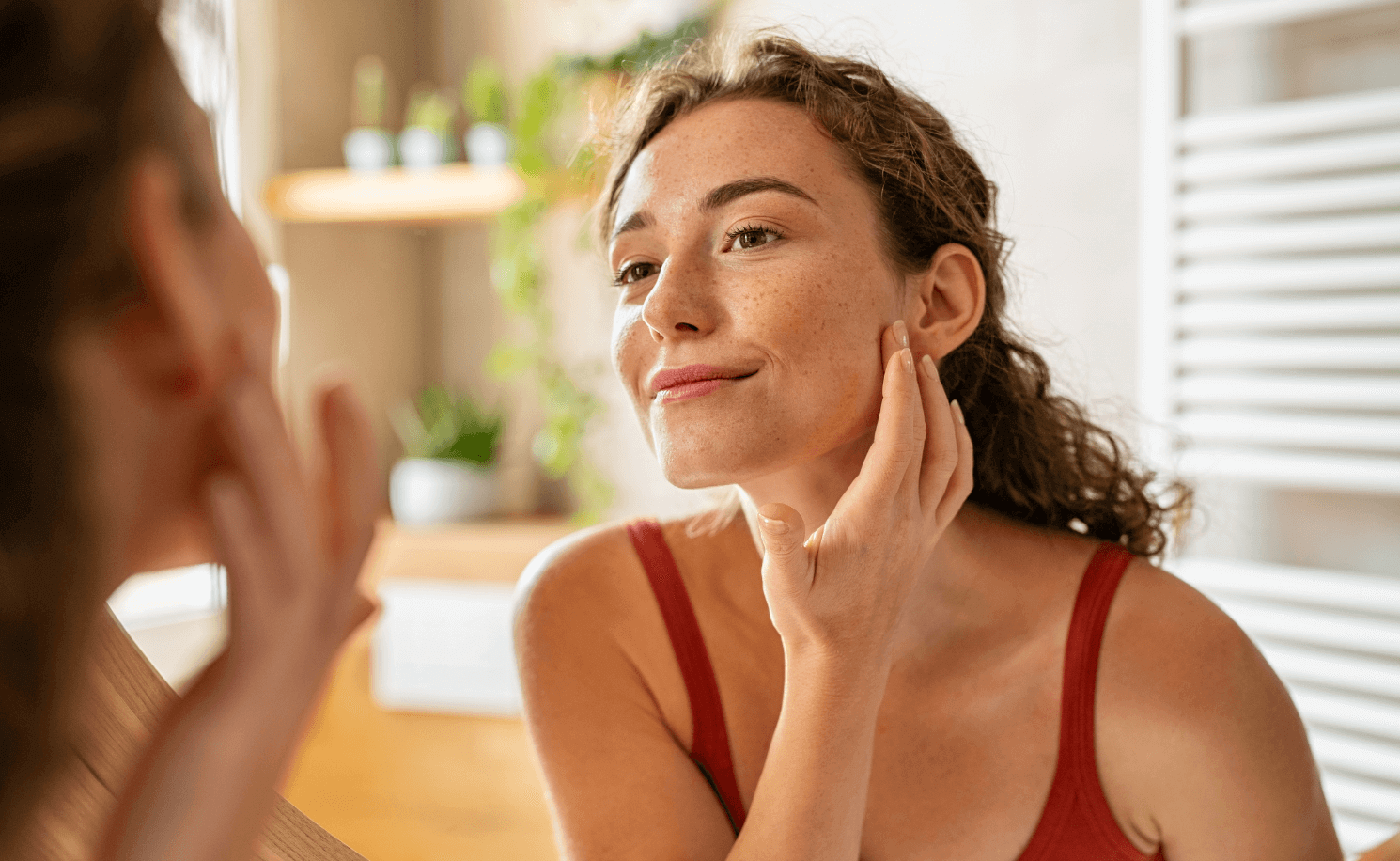 A woman looking in the mirror after chemical peel